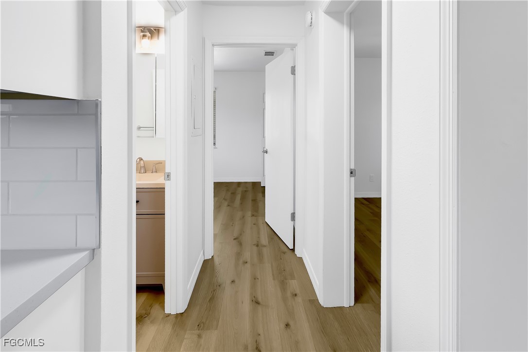 10697 Holly Road Bokeelia, FL 33922 - Photo 40 of 50 a view of hallway with wooden floor