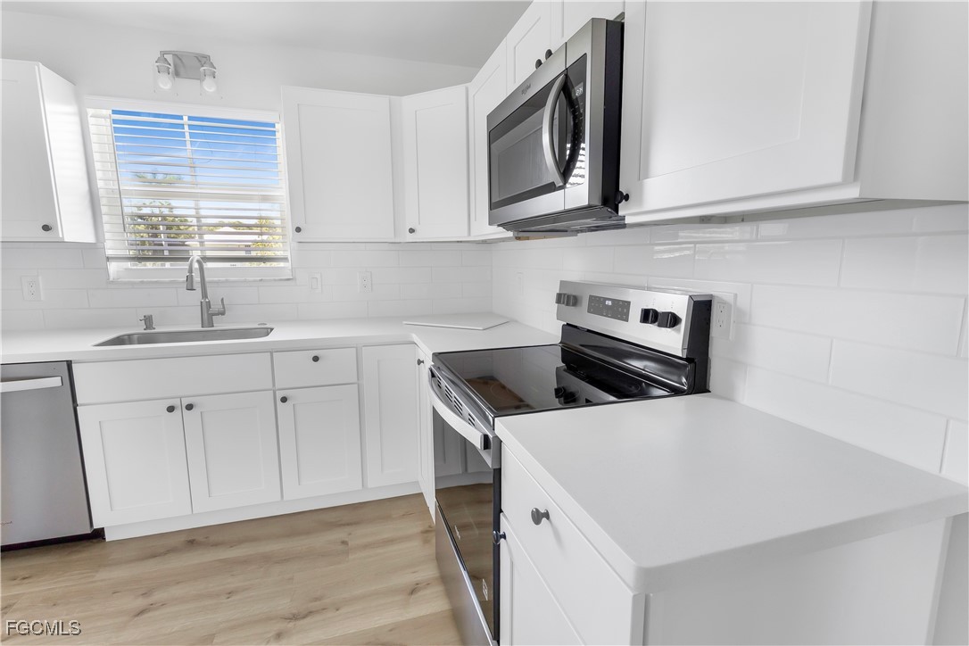 10697 Holly Road Bokeelia, FL 33922 - Photo 41 of 50 a kitchen with stainless steel appliances granite countertop a sink and a stove