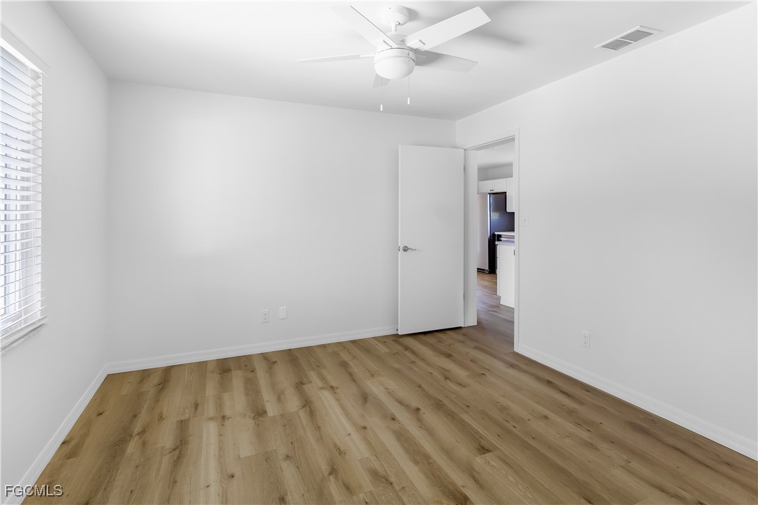 10697 Holly Road Bokeelia, FL 33922 - Photo 46 of 50 an empty room with wooden floor and windows