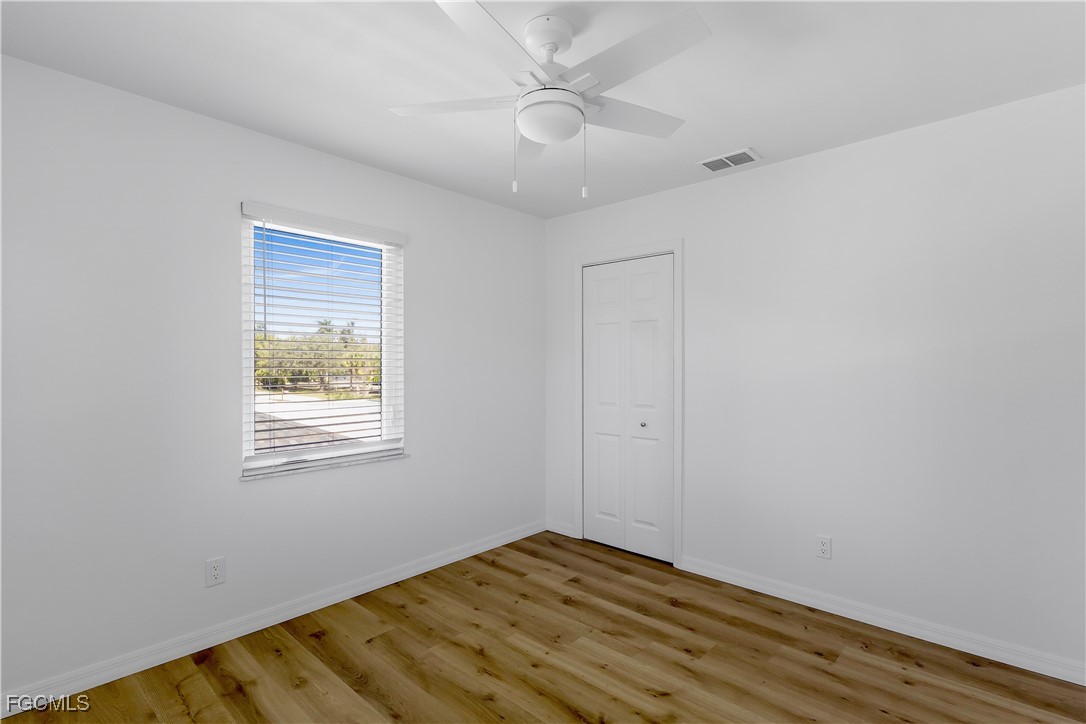 10697 Holly Road Bokeelia, FL 33922 - Photo 48 of 50 a view of an empty room with wooden floor and a window