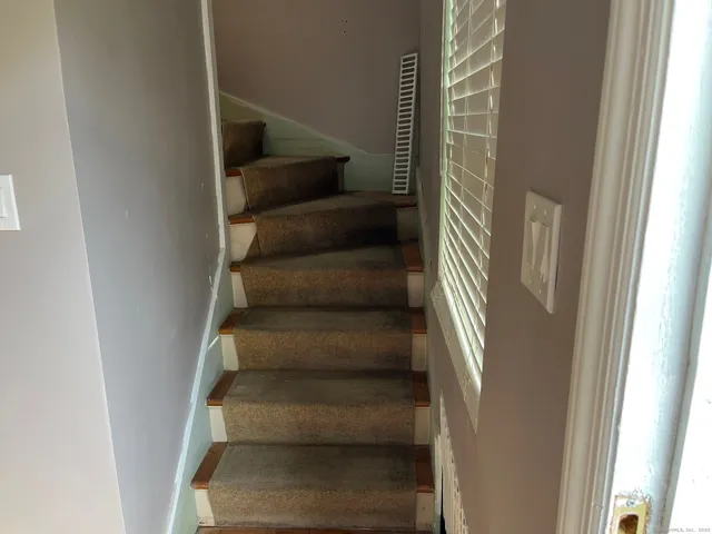 a view of staircase with white walls and windows