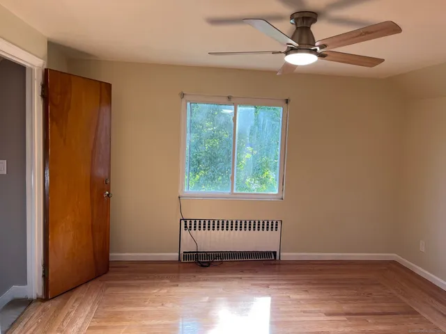 an empty room with a window and a ceiling fan