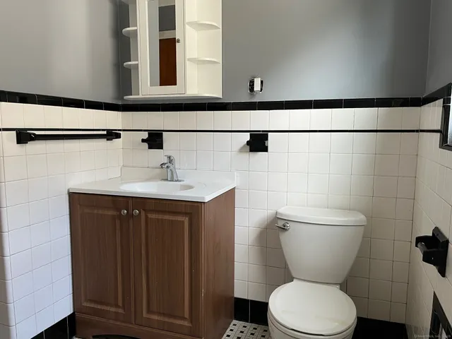 a bathroom with a toilet a sink and mirror
