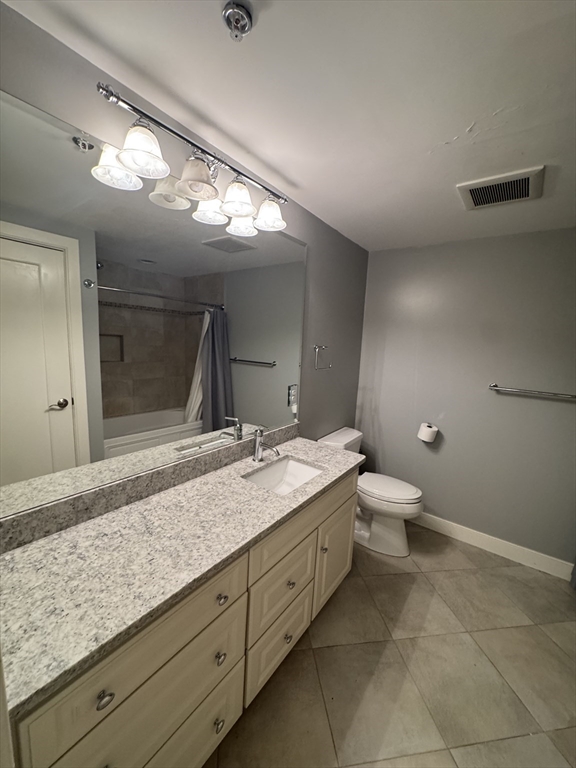 491 Dutton Street, Unit 504 Lowell, MA 01854 - Photo 15 of 16 a bathroom with a granite countertop sink a toilet and a mirror