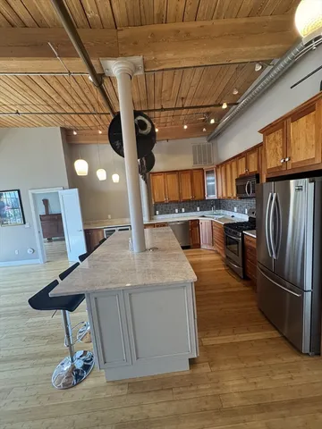 a kitchen with stainless steel appliances granite countertop a sink a stove and a refrigerator