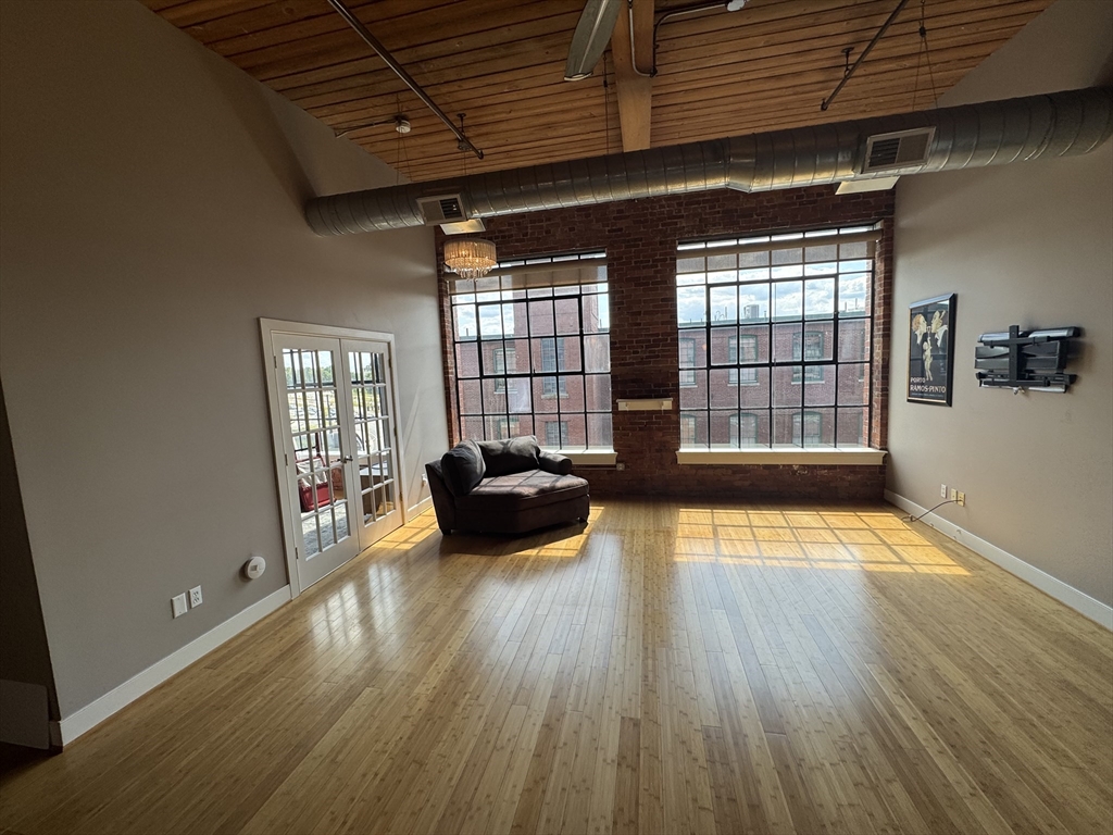 491 Dutton Street, Unit 504 Lowell, MA 01854 - Photo 5 of 16 a view of livingroom with wooden floor and couch