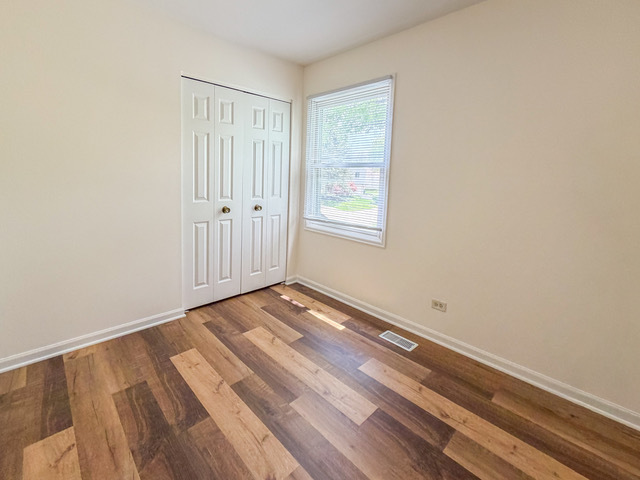 5090 Prairie Oak Road Gurnee, IL 60031 - Photo 11 of 30 a view of an empty room with wooden floor and a window