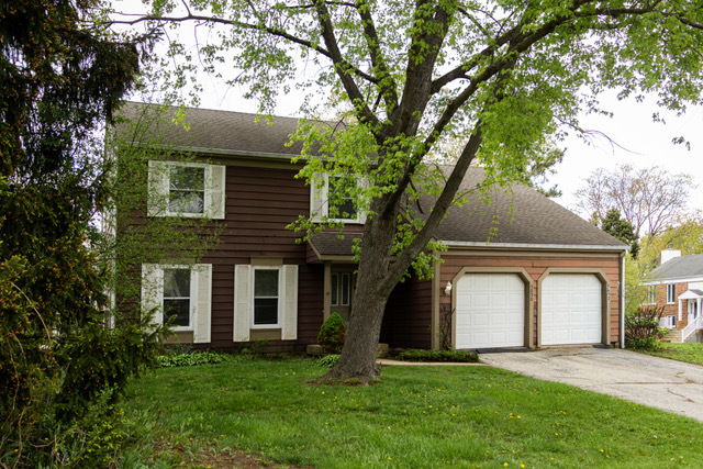 5090 Prairie Oak Road Gurnee, IL 60031 - Photo 2 of 30 a front view of a house with a garden and trees