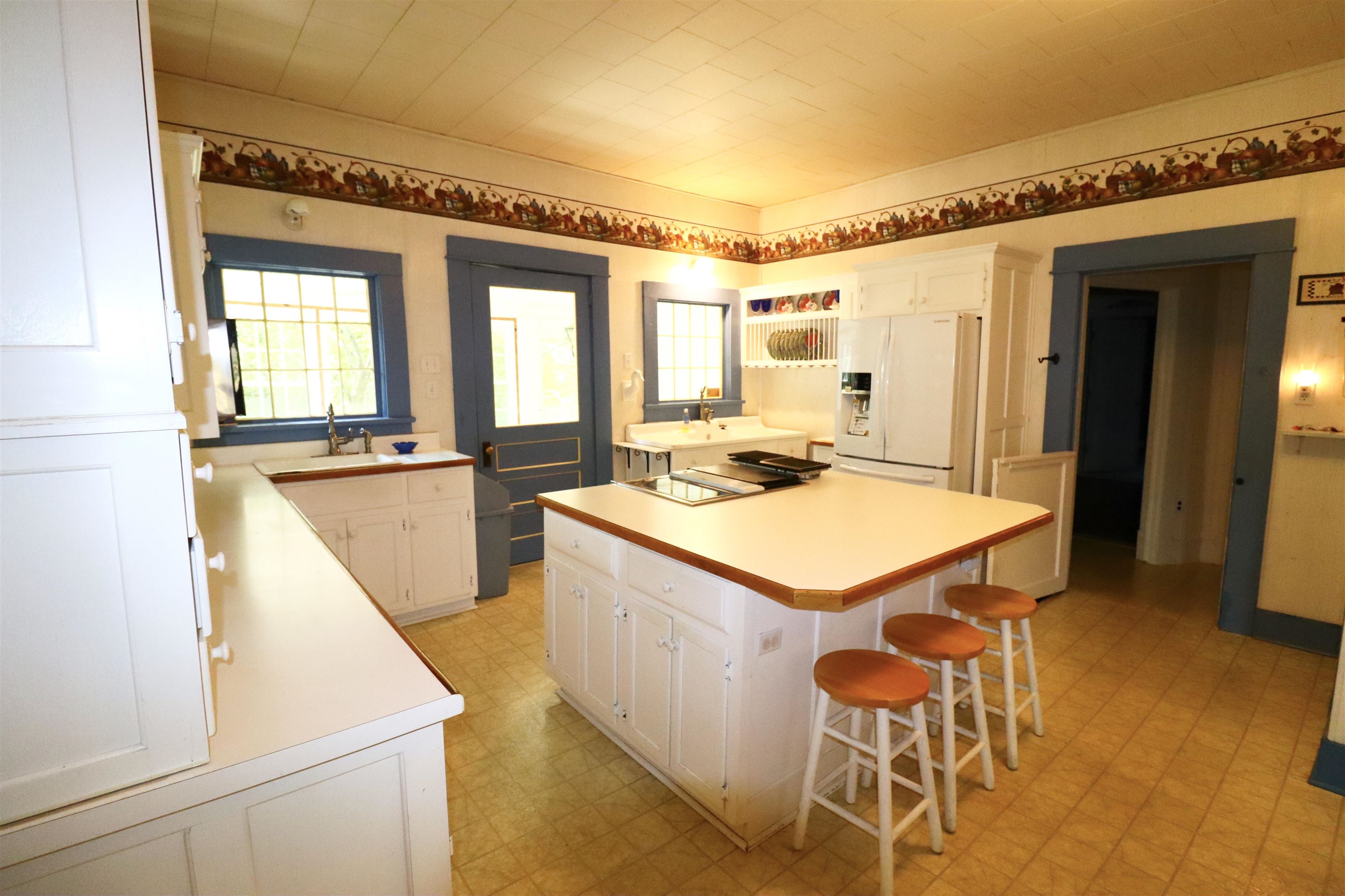 317 Purdy Road Selmer, TN 38375 - Photo 11 of 38 Kitchen with a breakfast bar, a center island, white cabinetry, white fridge with ice dispenser, and light tile patterned flooring