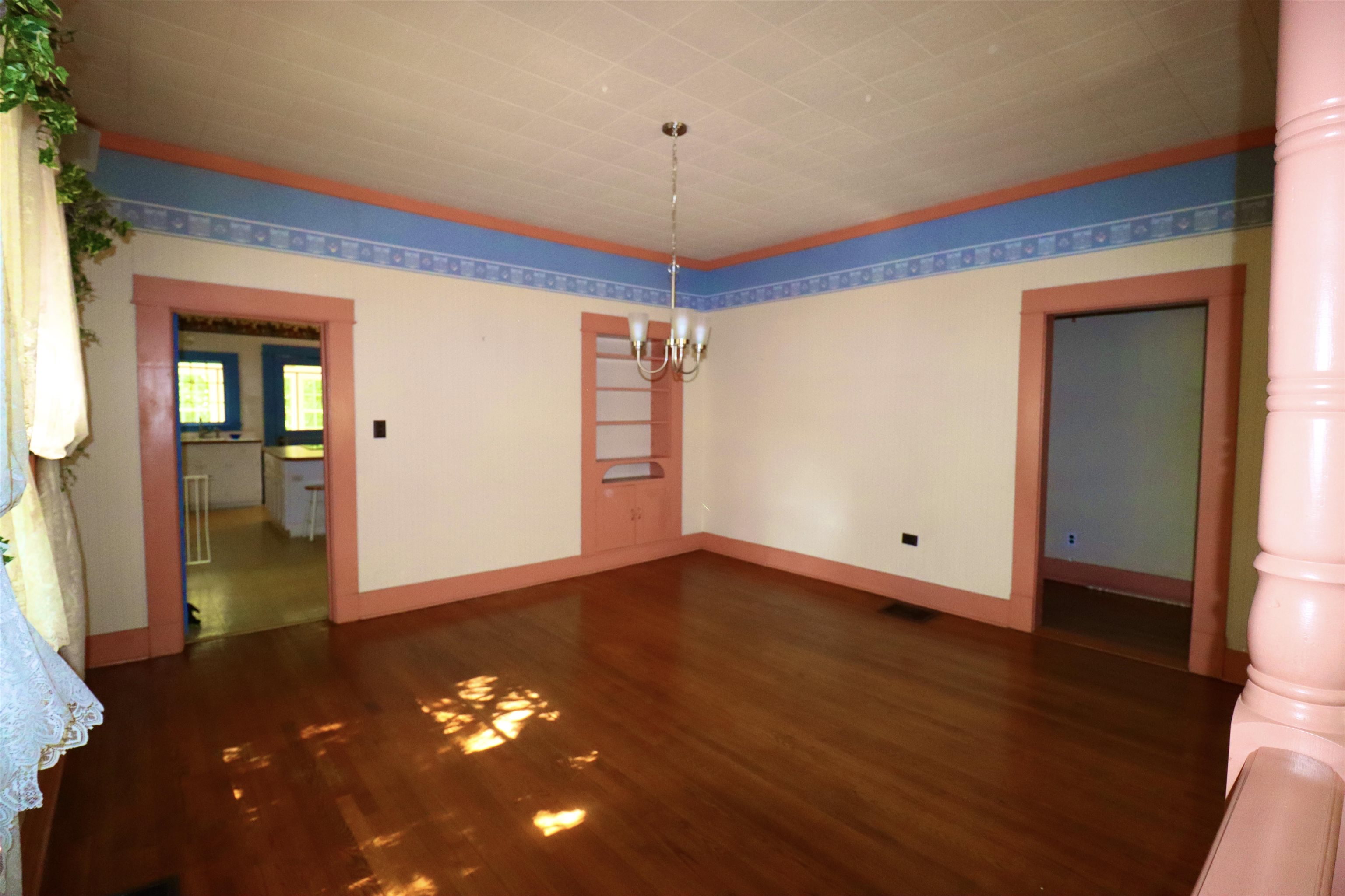 317 Purdy Road Selmer, TN 38375 - Photo 14 of 38 Empty room featuring dark wood-type flooring and a chandelier