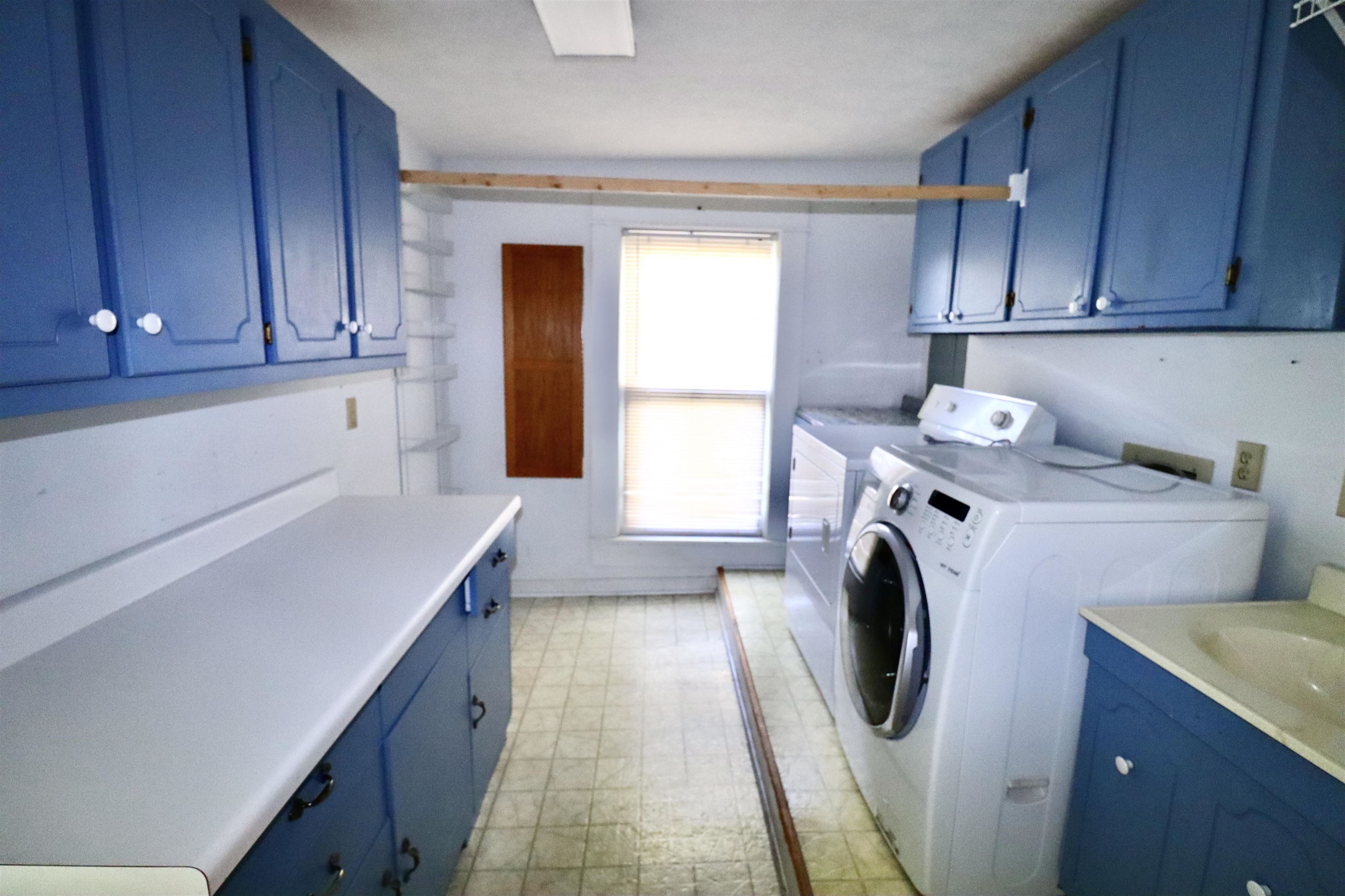 317 Purdy Road Selmer, TN 38375 - Photo 20 of 38 Laundry area featuring washing machine and clothes dryer, cabinets, and light tile patterned floors
