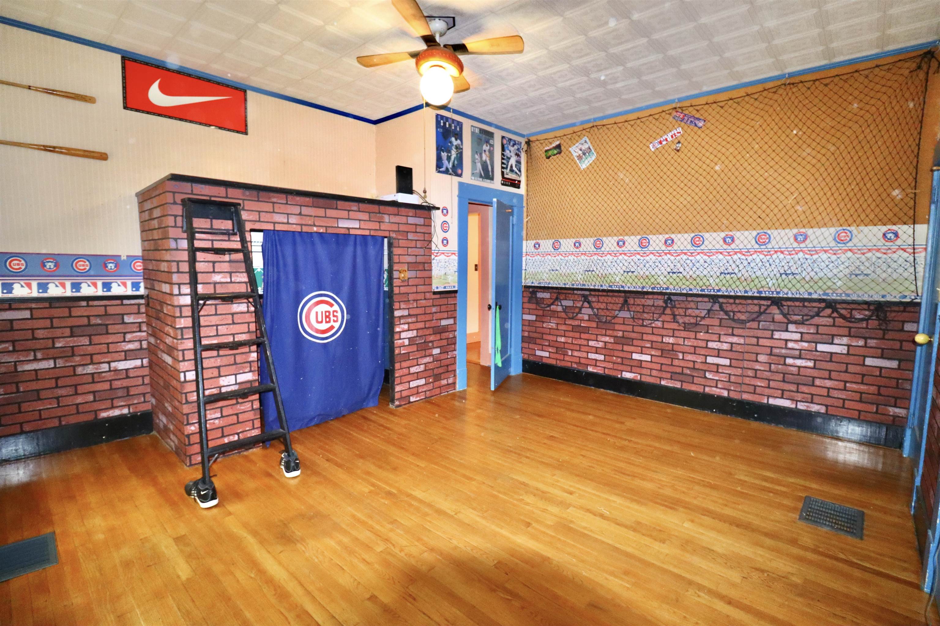 317 Purdy Road Selmer, TN 38375 - Photo 28 of 38 Unfurnished bedroom featuring hardwood / wood-style flooring, brick wall, and ceiling fan
