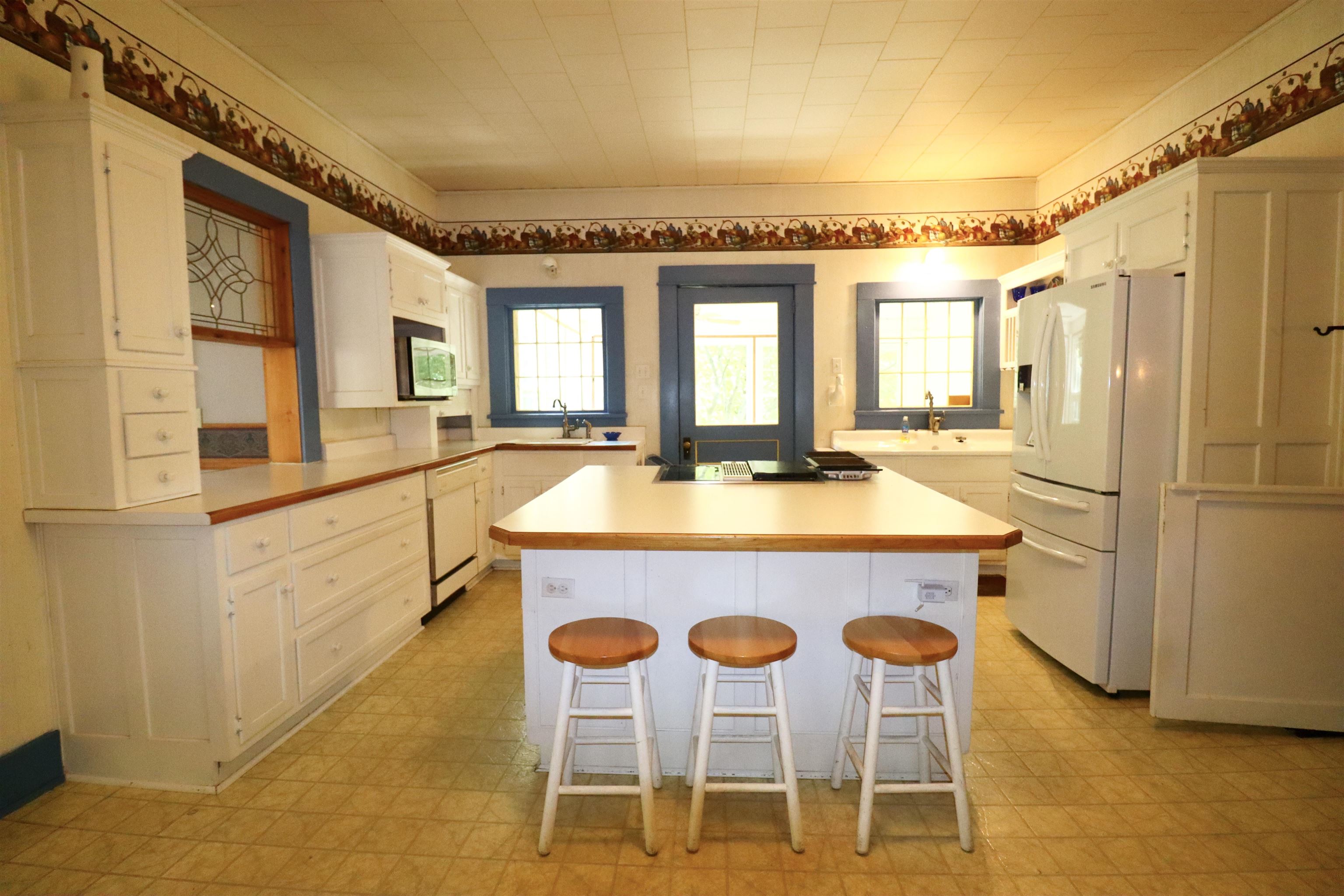 317 Purdy Road Selmer, TN 38375 - Photo 10 of 38 Kitchen with a kitchen bar, light tile patterned floors, white cabinets, and white refrigerator with ice dispenser