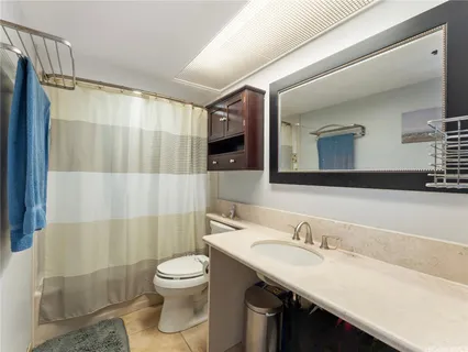 a bathroom with a granite countertop sink toilet a mirror a vanity and shower