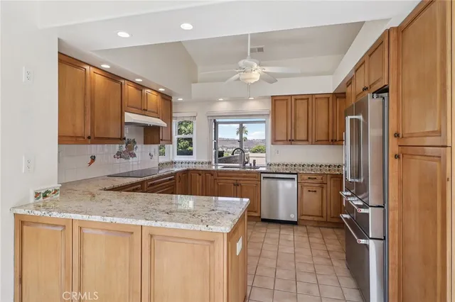 a kitchen with granite countertop stainless steel appliances and refrigerator
