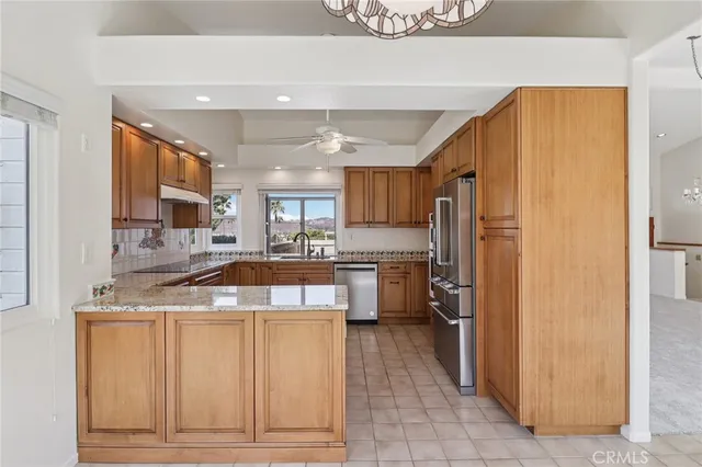 a kitchen with granite countertop a refrigerator and a sink