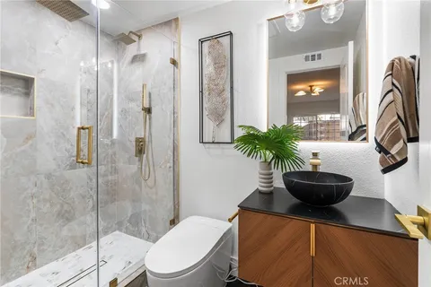 a bathroom with a granite countertop shower a mirror and window