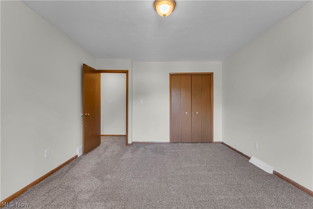 2540 Charney Road University Heights, OH 44118 - Photo 27 of 44 Spacious room featuring neutral carpeting, light-toned walls, and wood-finish trim