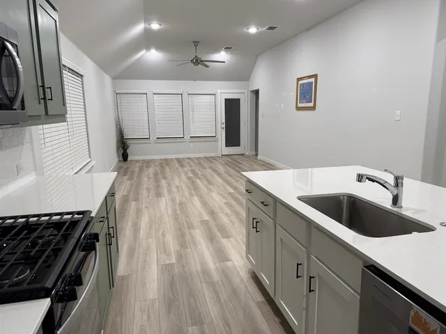 a large kitchen with kitchen island a sink stainless steel appliances and cabinets