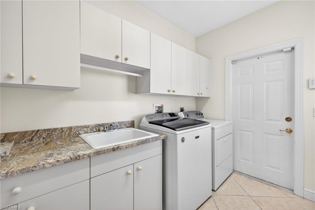 2229 Goshawk Court Naples, FL 34105 - Photo 17 of 27 a kitchen with granite countertop a sink a stove and cabinets