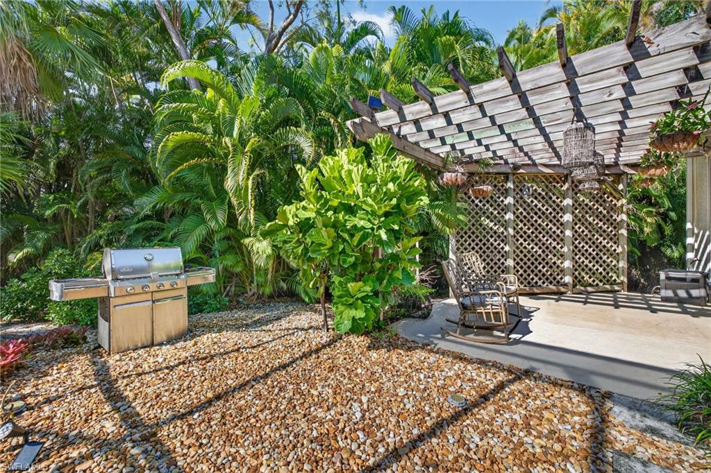 2229 Goshawk Court Naples, FL 34105 - Photo 21 of 27 a view of a backyard with plants and trees