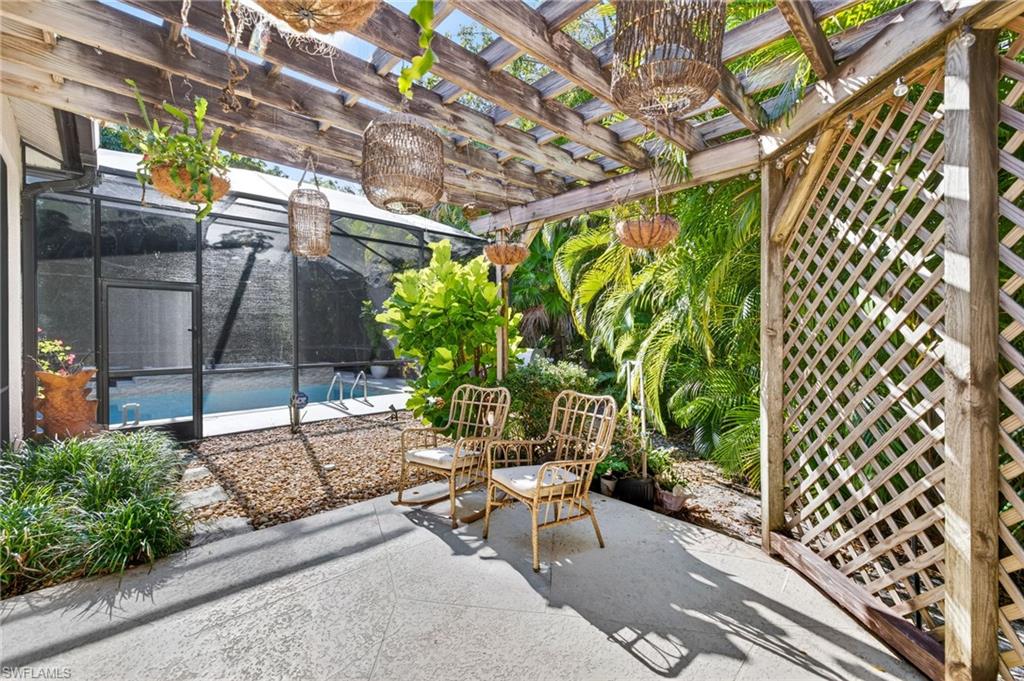 2229 Goshawk Court Naples, FL 34105 - Photo 22 of 27 a view of a patio with table and chairs and potted plants