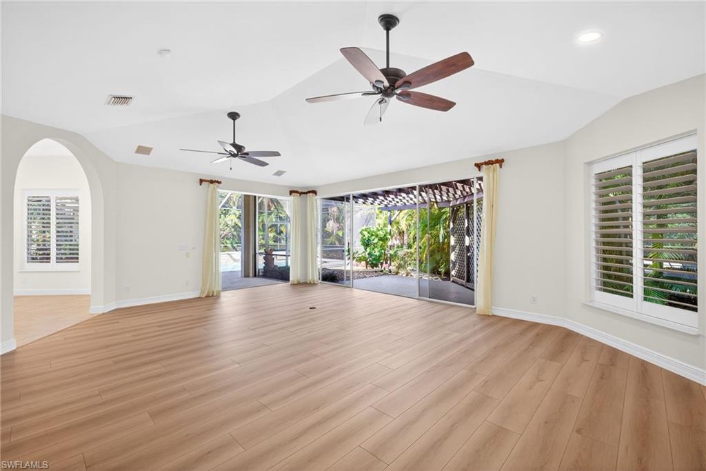 2229 Goshawk Court Naples, FL 34105 - Photo 9 of 27 a view of an empty room with wooden floor and a window