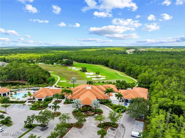 an aerial view of a tennis ground with a swimming pool
