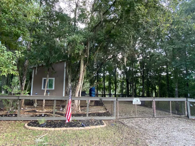 a view of house with swimming pool and trees in the background