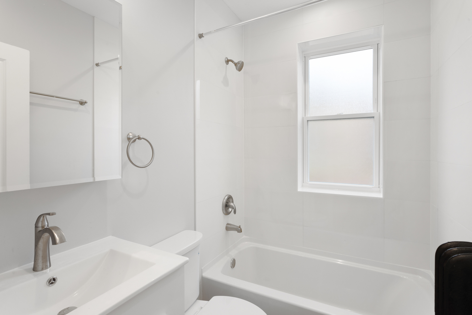 7383 North Damen Avenue, Unit 2W Chicago, IL 60645 - Photo 12 of 13 a bathroom with a tub shower vanity and a sink
