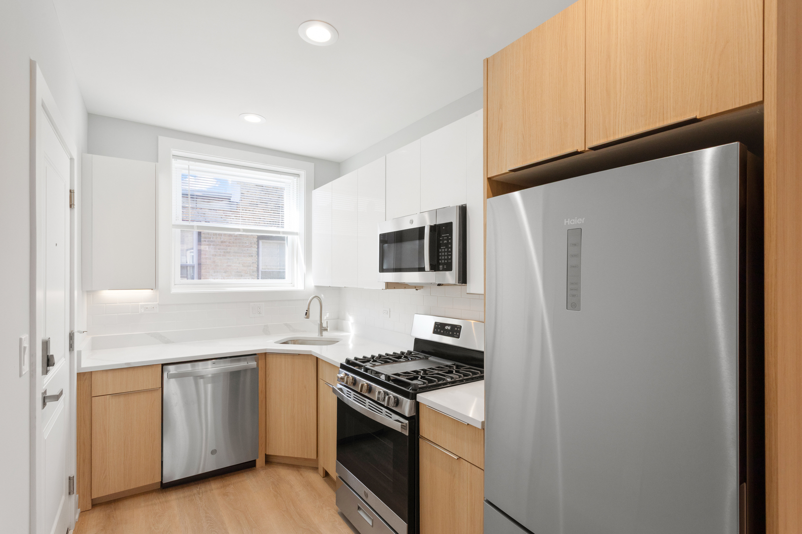 7383 North Damen Avenue, Unit 2W Chicago, IL 60645 - Photo 3 of 13 a kitchen with white cabinets and white appliances