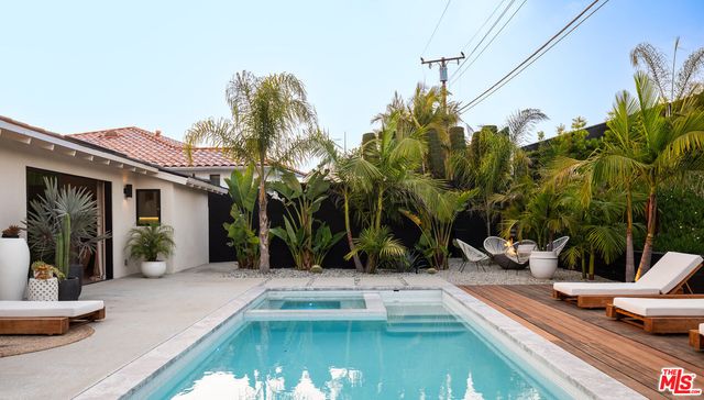 a view of a patio with couple of chairs and potted plants