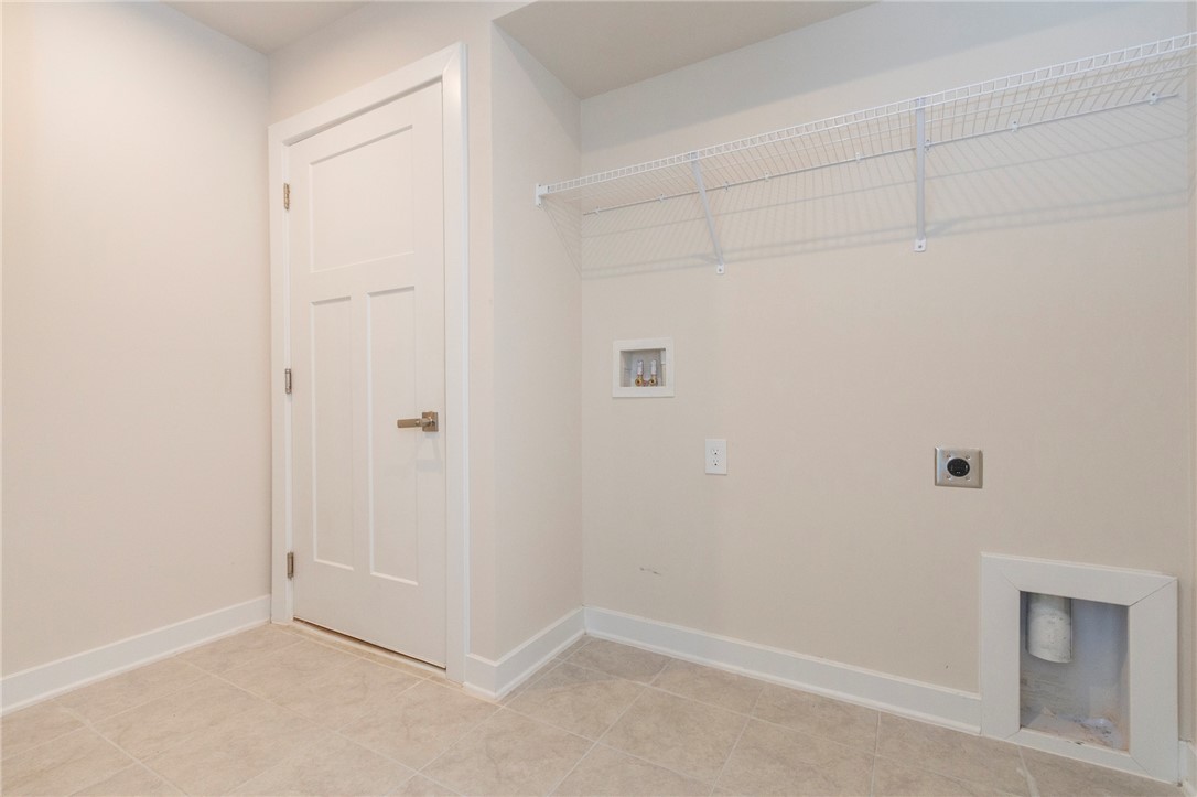 233 Scenic Road Anderson, SC 29621 - Photo 25 of 50 A well-lit utility room features a wire shelf and tiled flooring, ready for your appliances.