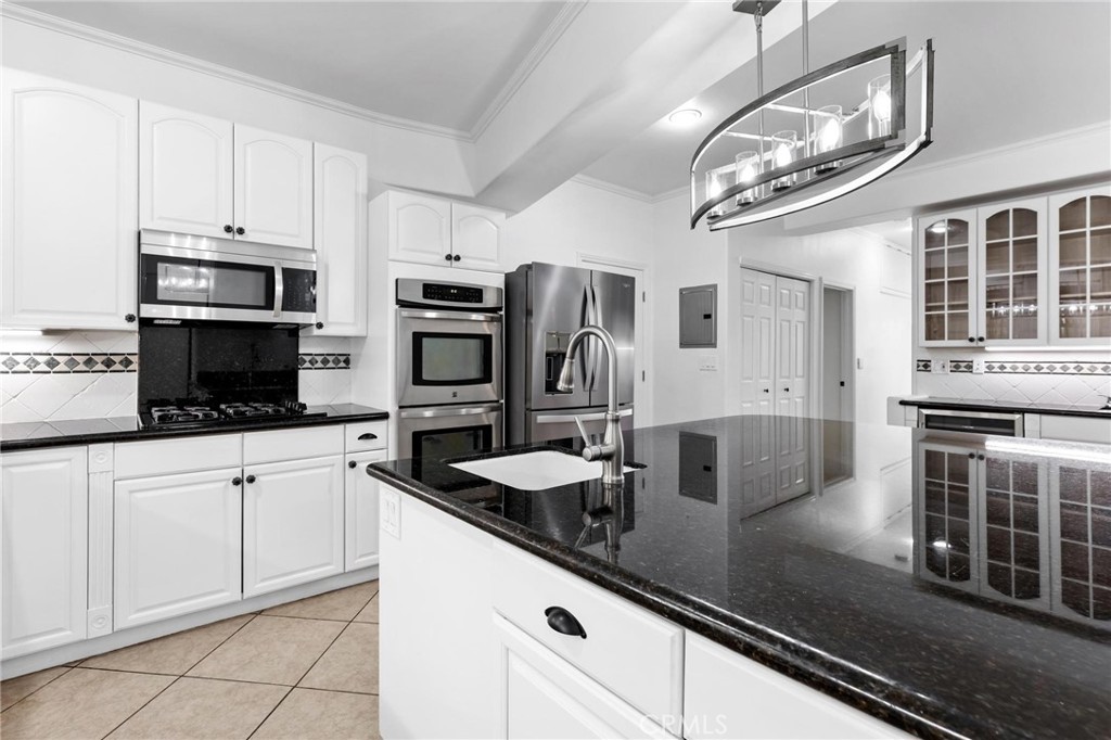 22870 Trigger Street Chatsworth, CA 91311 - Photo 23 of 64 a kitchen with stainless steel appliances granite countertop a sink a stove and cabinets