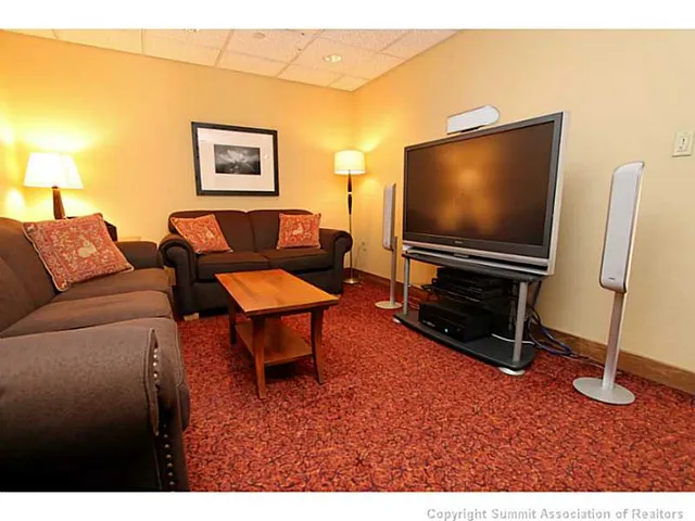 a living room with furniture a flat screen tv and a window