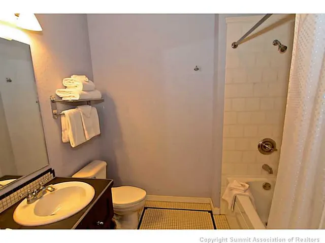 a bathroom with a sink mirror vanity and toilet