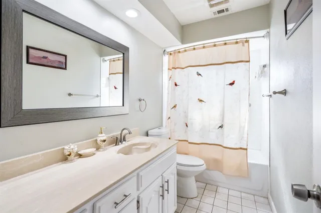 a bathroom with a granite countertop sink a toilet and shower