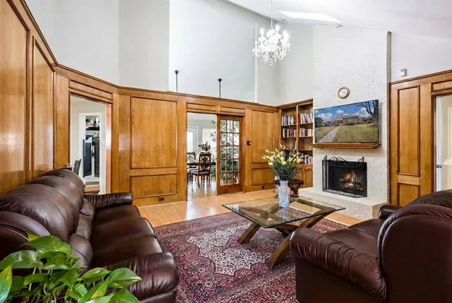 a living room with furniture a fireplace and a chandelier