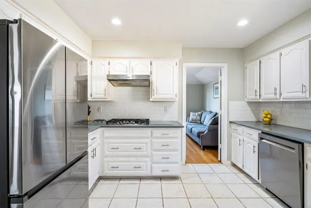 a kitchen with stainless steel appliances granite countertop a stove a refrigerator and a cabinets