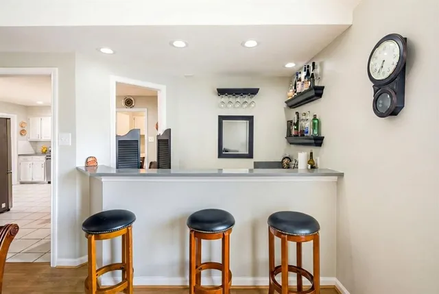 a group of chairs sitting in a kitchen and a table in a kitchen
