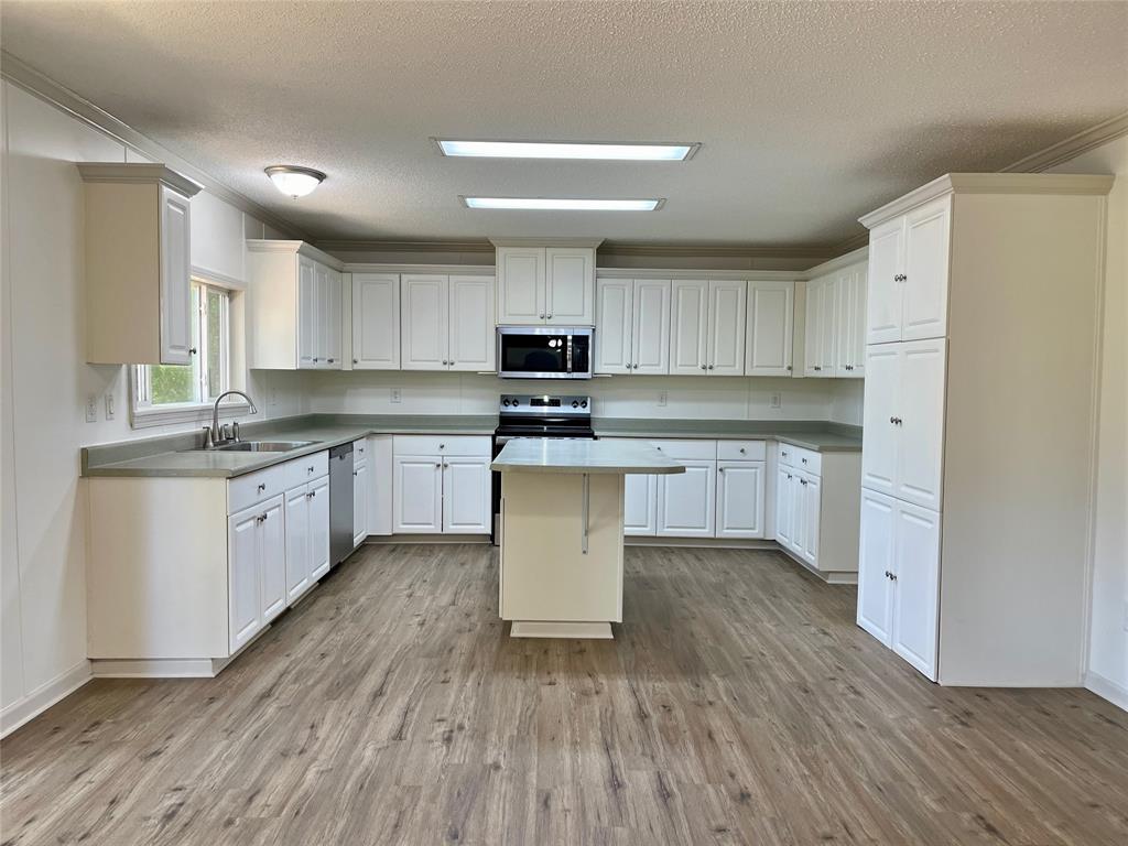 6913 Rice Road Shreveport, LA 71129 - Photo 18 of 26 a kitchen with granite countertop a sink cabinets and wooden floor