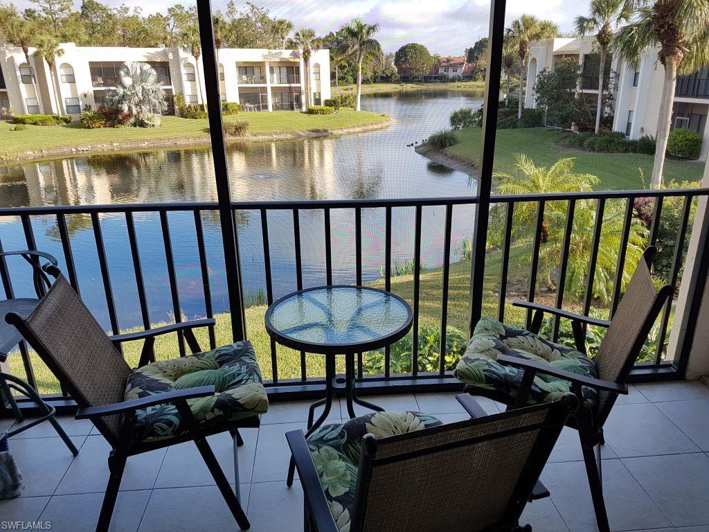 3324 Olympic Drive, Unit 324 Naples, FL 34105 - Photo 1 of 12 a view of a balcony with chairs and wooden floor