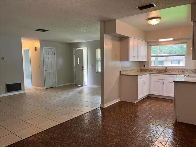 a kitchen with white cabinets and appliances