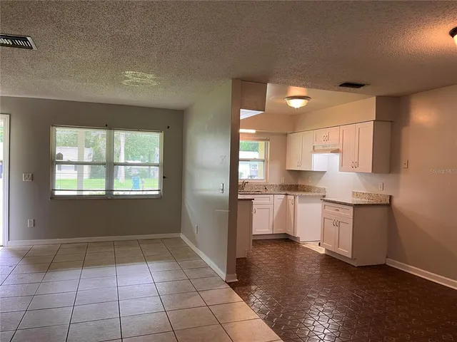 a kitchen with a sink window and cabinets