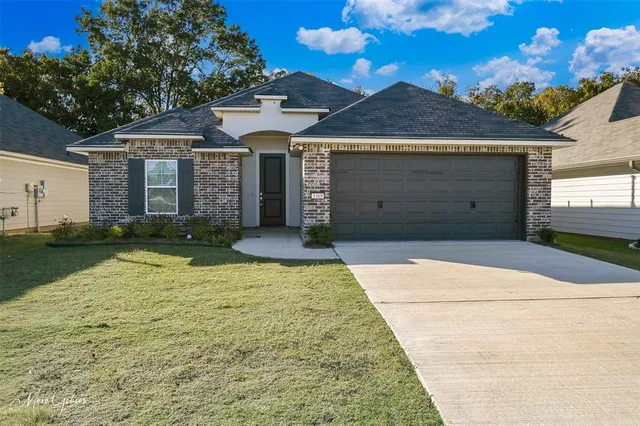 a front view of a house with a yard and garage