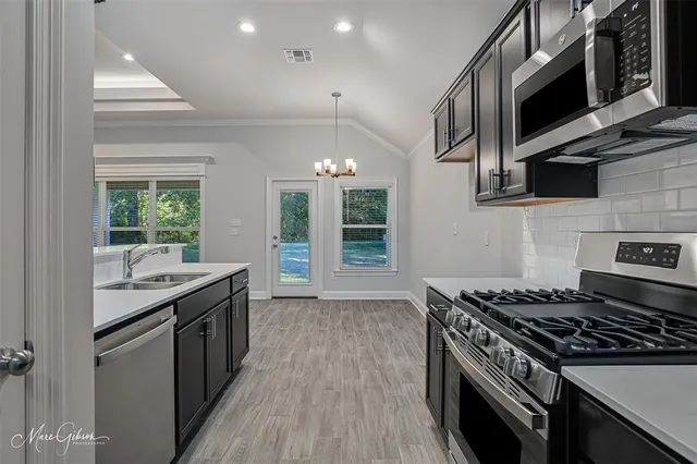 a kitchen with stainless steel appliances granite countertop a stove and a sink
