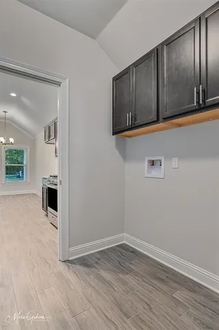 a view of a kitchen with wooden floor and a hallway