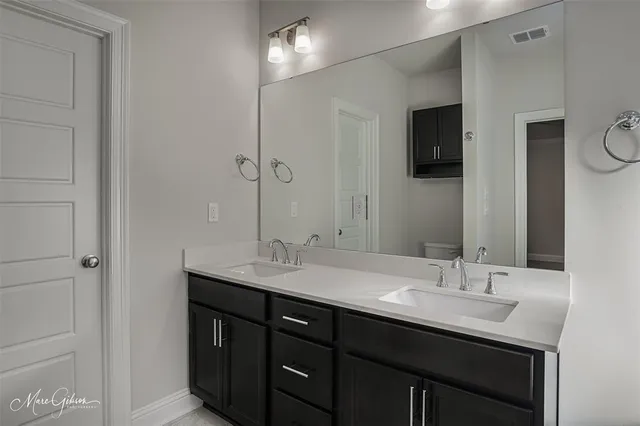 a bathroom with double sink and two mirror