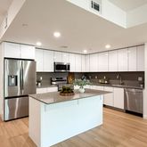 a kitchen with refrigerator a sink and wooden cabinets