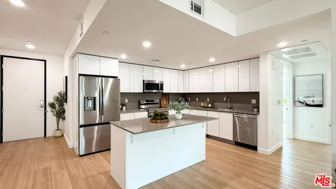a kitchen with refrigerator a sink and wooden cabinets